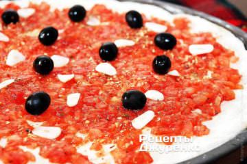 Черные маслины без косточек разрезать пополам и также разложить поверх соуса маринара