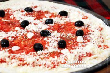 Посыпать пиццу ближе к краю поверх соуса маринара тертым пармезаном
