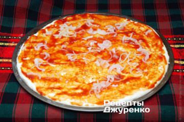 Томатным соусом смазать тесто и выложить лук