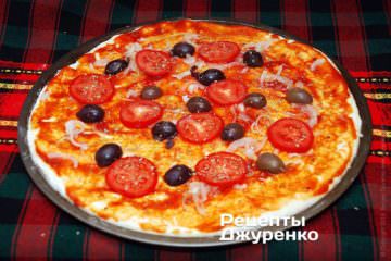 Разложить половинки оливок и кусочки помидоров
