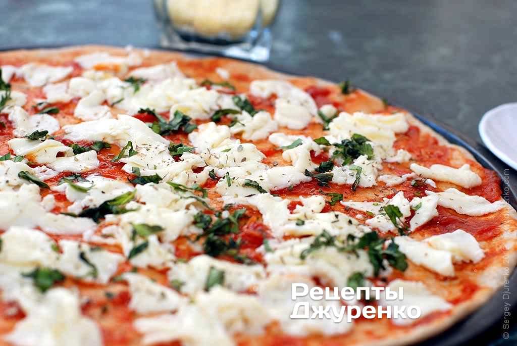 Посыпать пиццу зеленым базиликом.