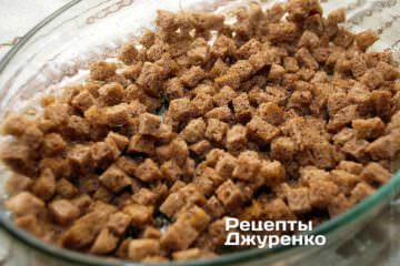 Влить в форму оливковое масло и размазать его по дну. Высыпать в форму подготовленный хлеб и аккуратно перемешивать его добавить оливковое масло