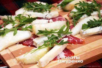 На скибочки м'яса викласти грушу, сир і рукколу