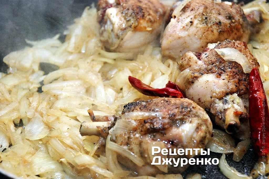 Добавить к обжаренной курице нарезанный лук и помешивая обжаривать на среднем огне.