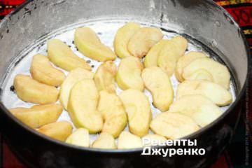 Половину фруктов разложить на дно формы и залить тестом.