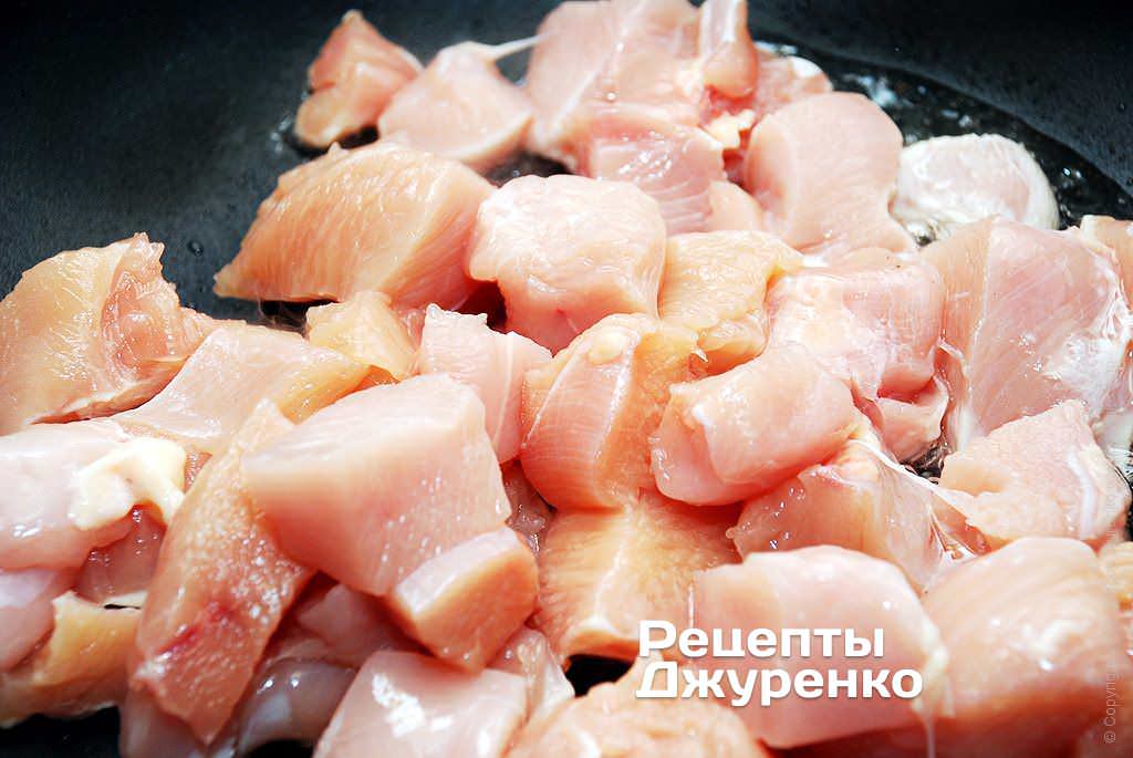 Выложить кусочки курицы в разогретое масло.