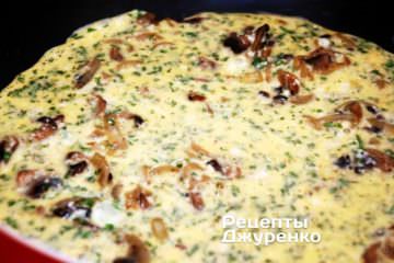 Залить лук и грибы яичной смесью.