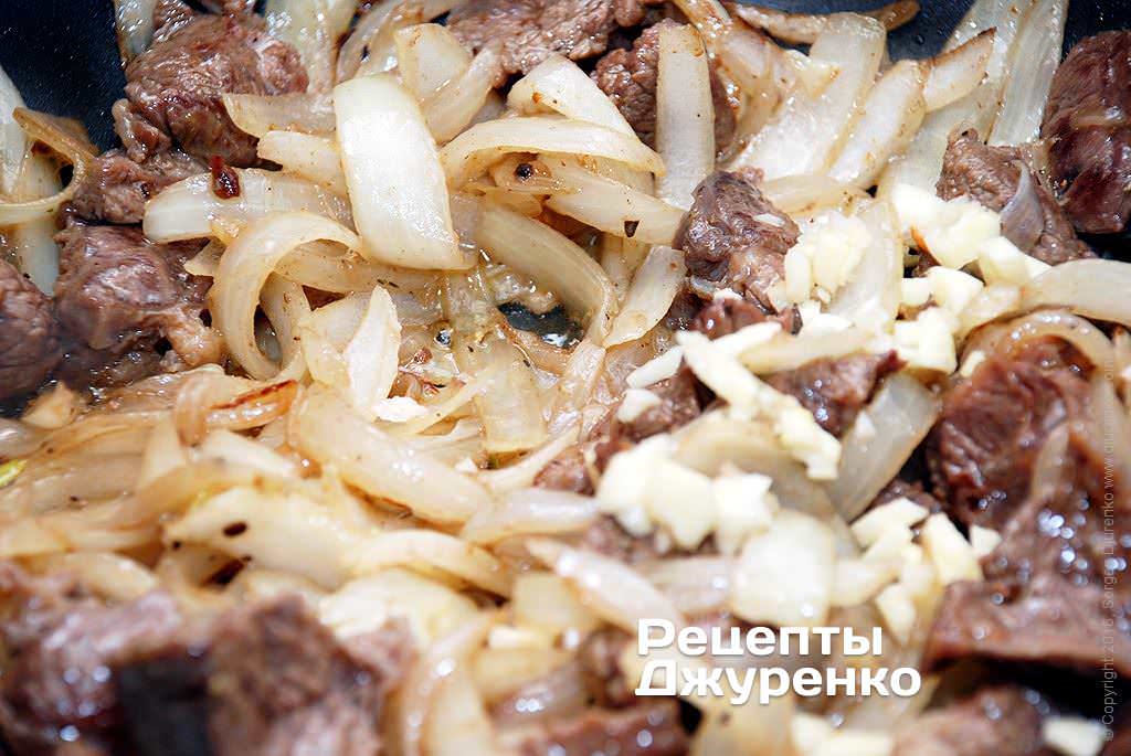 Тушить мясо с луком под крышкой.