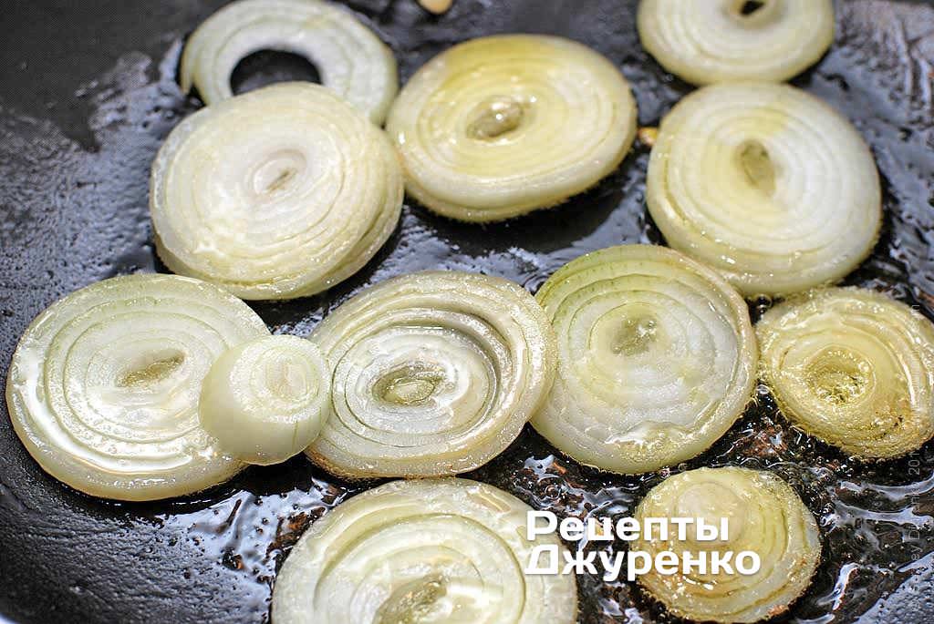 Обжарить лук, нарезанный колечками.