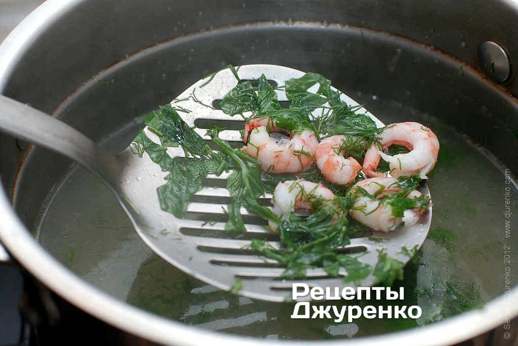 В бульон добавить зелень и мясо креветок.