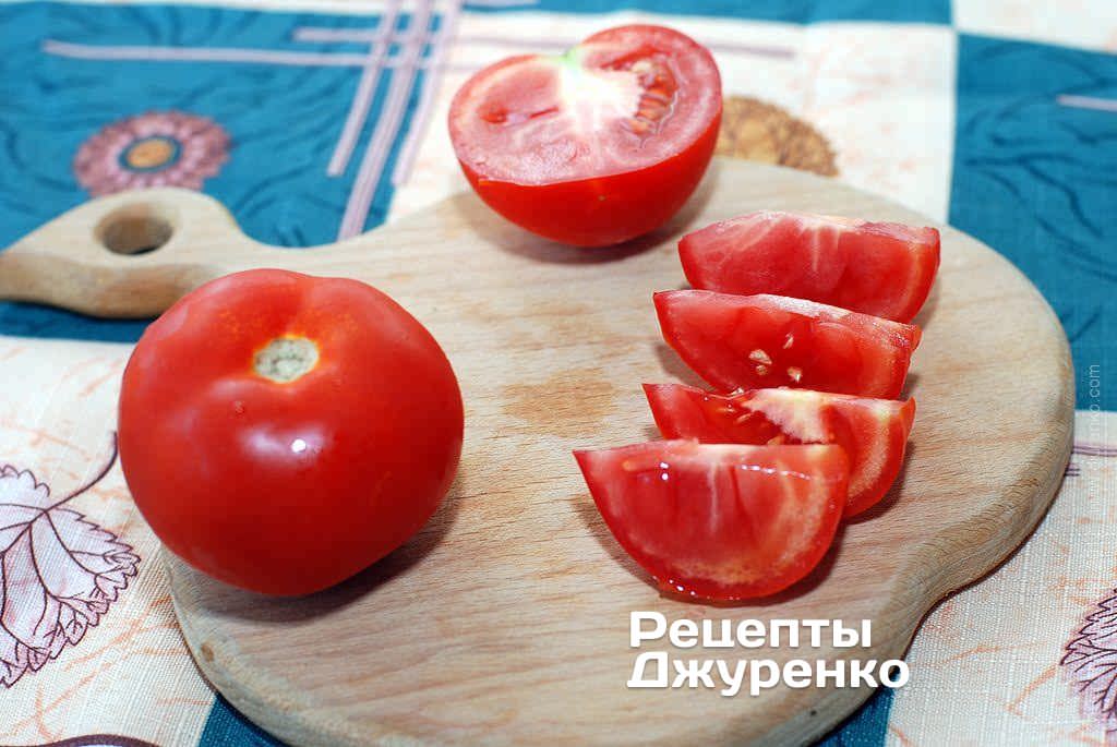 Нарізати помідори часточками.