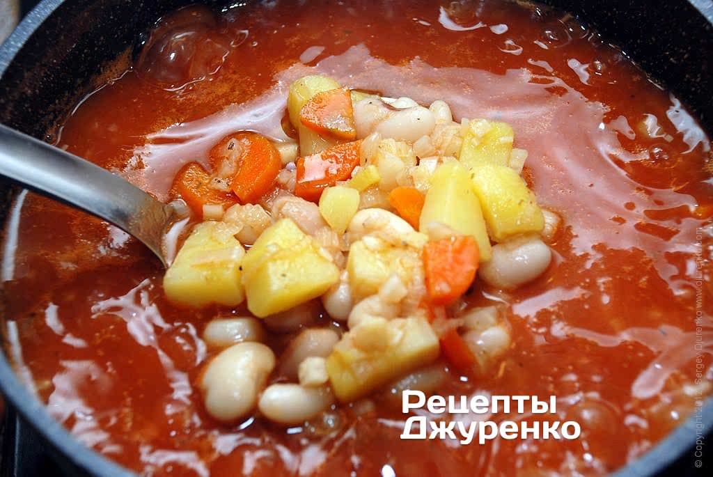 Варить томатный суп с фасолью несколько минут.