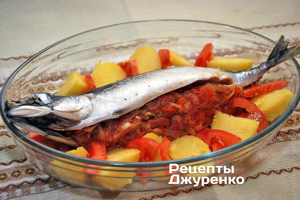 Вокруг рыбы уложить печеный картофель и помидоры.