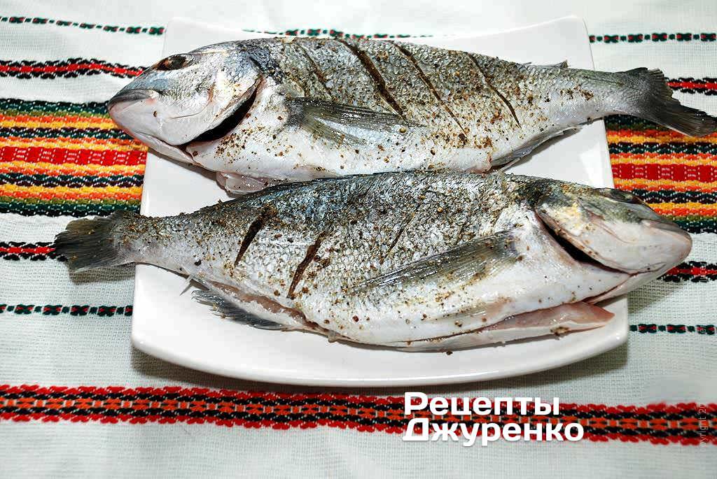 Подготовленную рыбу надрезать по бокам наискосок через 3-4 см.