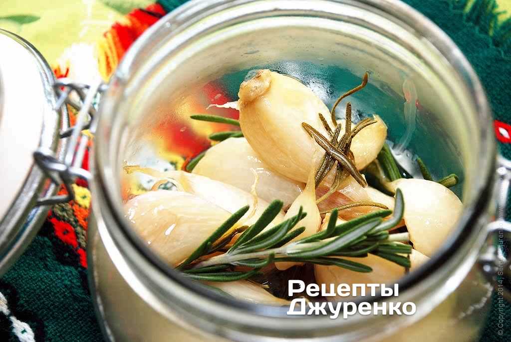 Зняти каструлю з вогню, за допомогою ложки вибрати з олії часточки часнику і перекласти їх в суху банку, яку можна закупорити.