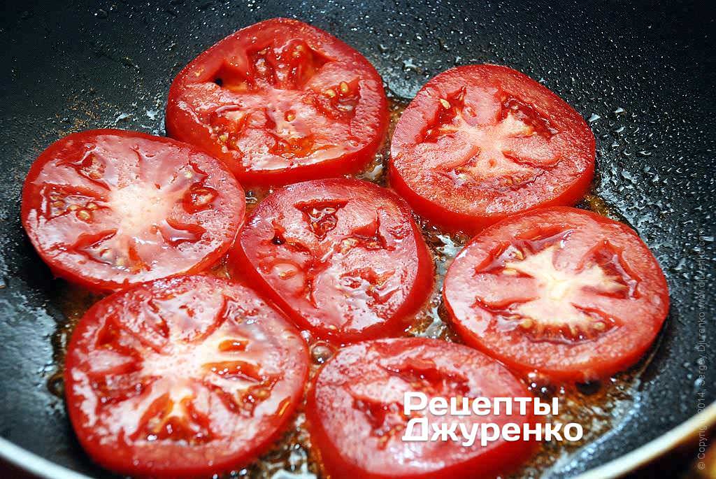 Помидор разрезать на кружочки толщиной 3-4 мм. Обжарить помидор на масле по 1 минуте с каждой стороны.