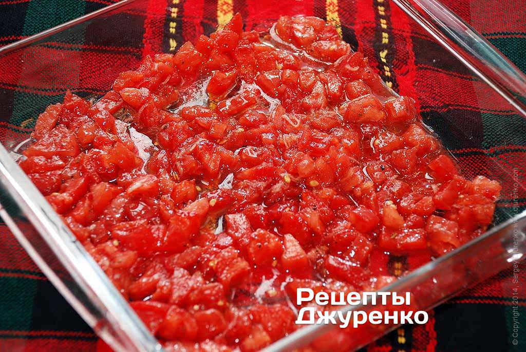 В подходящую по размеру форму выложить половину измельченных томатов.