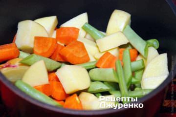 В небольшую кастрюлю сложить нарезанную морковку, картошку и спаржевую фасоль. Залить холодной водой вровень с овощами.