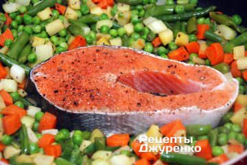 Выложить к овощам стейк семги.