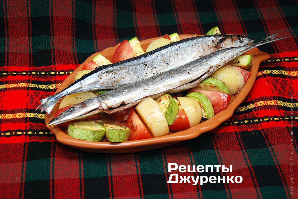 Поверх овощей выложить подготовленные тушки рыбы.