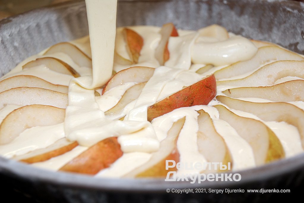 Розкласти половину часточок груш і залити тістом.