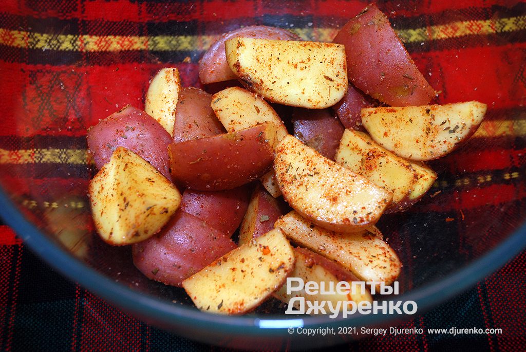 Картофель нарезать дольками и смешать со специями.