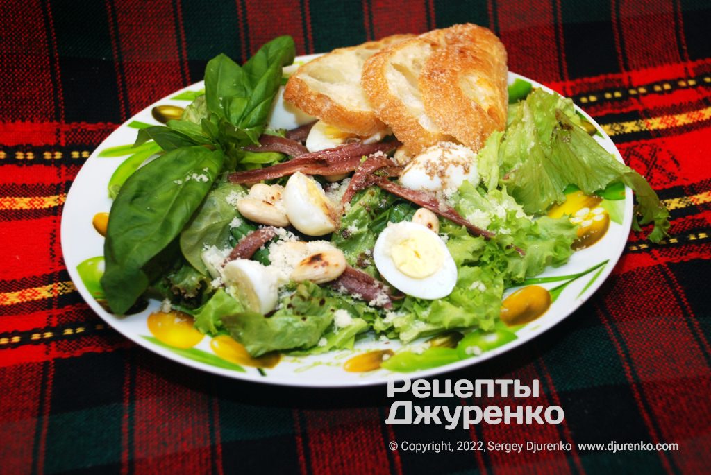 Салат с анчоусами в масле, зелеными листьями, яйцами и миндалем