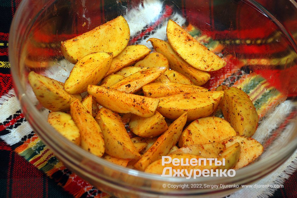 Картошка нарезается дольками и смешивается со специями.