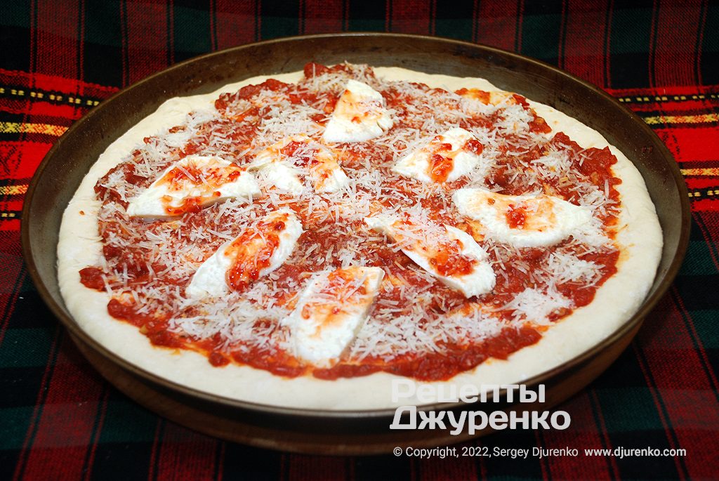 Посыпать пиццу с моцареллой пармезаном и побрызгать оливковым маслом.