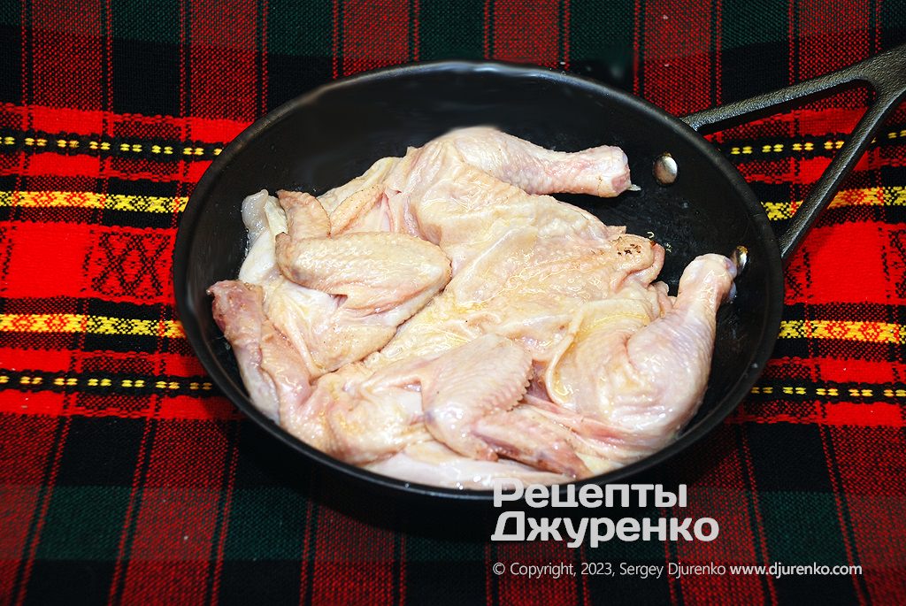 Растопить масло и уложить цыпленка на сковородку.