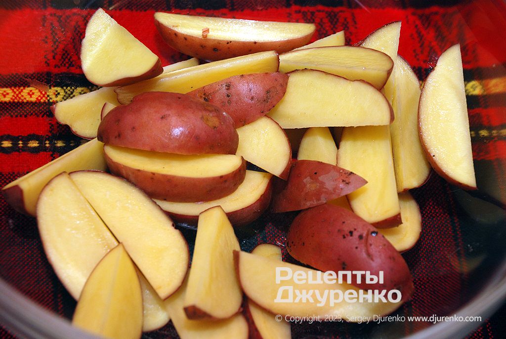 Картоплю нарізати часточками разом із шкіркою.