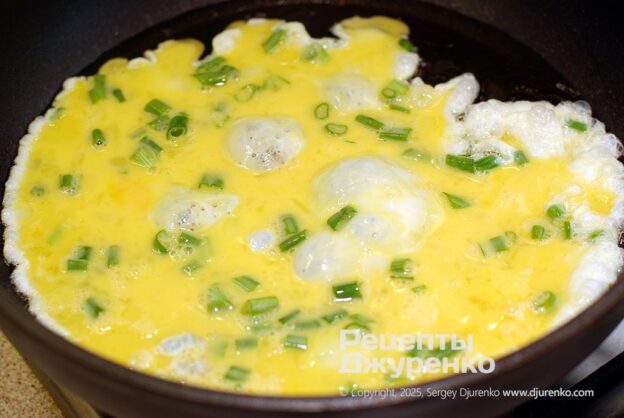 Pouring the eggs into the hot oil.