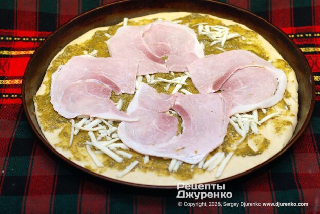 Выложить тонко нарезанную ветчину.