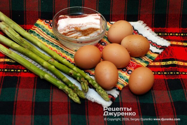 Свежие домашние яйца, сырокопченый бекон и стебли спаржи.